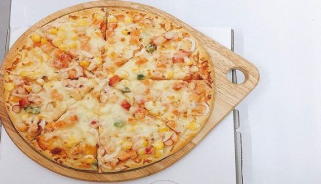 Pizza của Pou Pizza có phần đế dày và giòn, bên trên là nhiều loại nguyên liệu khác nhau như thịt và cá, xúc xích, bạch tuộc... | Nguồn: Pou Pizza 